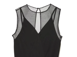 Detail of elegant black dress showing V-neck design and sheer mesh patchwork textures