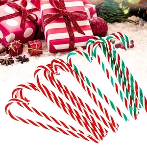 Red and green striped Christmas candy cane ornaments arranged with festive gift boxes