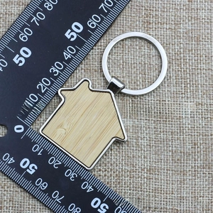 Macro view of house-shaped wood and metal keychain with 4cm scale measurement
