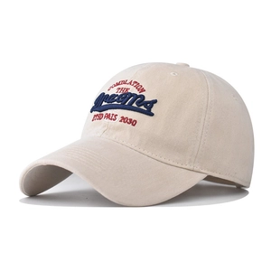 Close-up of beige cotton baseball cap with 3D embroidery detail and red blue lettering