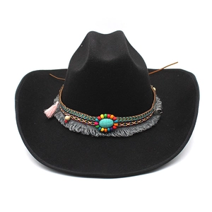 Detail of black felt fedora hat featuring a bohemian beaded band with turquoise and tassels
