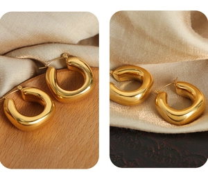 Macro detail of chunky gold U-shaped hoop earrings with a high-polished mirror finish
