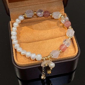 Detail of freshwater pearl and strawberry crystal bracelet in an orange velvet gift box