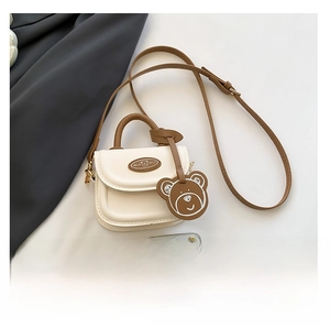 Mini flap crossbody bag size comparison with a smartphone and cute bear charm detail