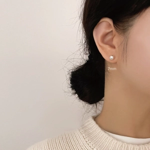 Detailed side view of a model wearing a 7mm minimalist silver ball stud earring