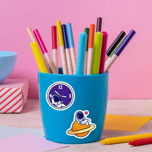 Close-up of waterproof astronaut stickers applied on a blue pen holder with markers