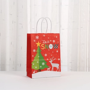 Detail of red Christmas paper gift bag with white reindeer and Let it Snow print