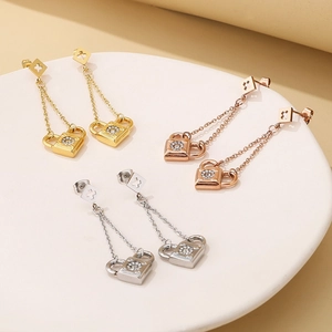 Detail of tassel earrings with lock pendants in gold, silver, and rose gold finishes