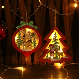 Illuminated red Christmas ornaments with Santa and reindeer scenes on dark wood
