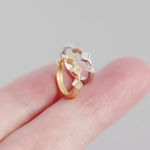 Close-up detail of s925 silver rhombic earrings with inlaid diamonds on fingers