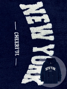 Close-up of white NEW YORK embroidery on a navy blue sherpa fleece hooded sweatshirt
