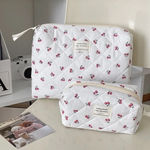 Detail of two-piece quilted cherry print makeup bags with embroidered mood labels