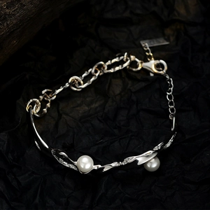 Irregular S925 sterling silver chain bracelet with white pearls on a black background