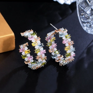 Detailed close-up of rainbow cubic zirconia gemstones on C-shaped hoop earrings