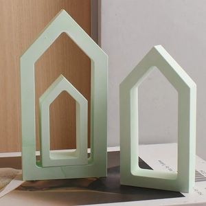 Three mint green minimalist hollow house sculptures in small, medium and large sizes