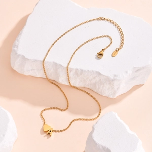 Golden stainless steel necklace featuring a 3D heart pendant and initial A on stone backdrop
