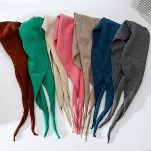Variety of colorful knitted triangle scarves in brown green beige and grey displayed