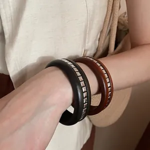Ensemble de joncs en bois rétro avec rivets métalliques, portés dans un style bohème chic