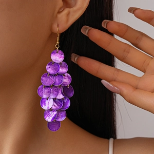 Detail of long layered purple shell disc drop earrings shown on a model