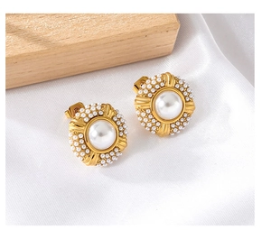 Close-up of vintage gold round earrings with large pearl and small pearl halo
