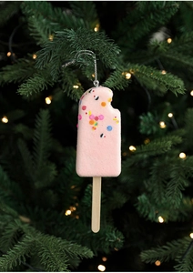 Detail of pink popsicle Christmas ornament with glitter and wooden stick on a tree