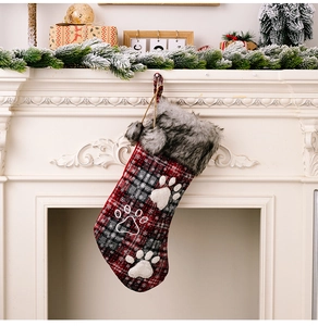 Close-up of red and black buffalo plaid Christmas stocking with grey faux fur and paw print