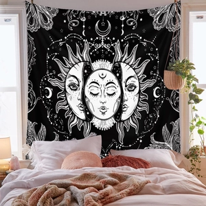 Detail of bohemian tapestry featuring sun and moon phases hung in a cozy bedroom
