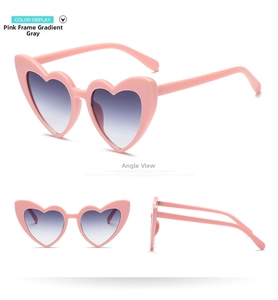Detail view of heart-shaped sunglasses with pink frames and gradient grey lenses