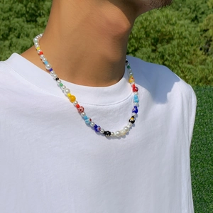 Colorful beaded necklace with pearls and glass flowers on a male model outdoors