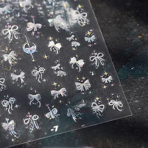 Vue macro des autocollants à ongles holographiques M-757 avec nœuds et motifs étoilés
