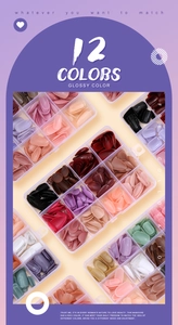 Détail de 12 couleurs d'ongles artificiels brillants dans une boîte de rangement