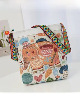 Detailed close-up of a canvas crossbody bag with colorful cartoon elephant embroidery