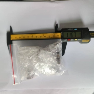 Digital caliper measuring a bag of small metal parts with high precision display