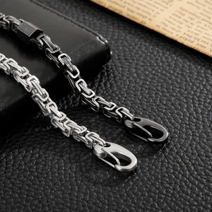 Close-up of silver and black stainless steel Byzantine chain bracelets with lobster clasps