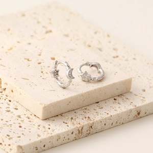 Detailed close-up of s925 silver huggie earrings with cubic zirconia star and moon charms