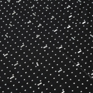 Macro detail of black mesh fabric with round and baguette-cut rhinestones for party dress