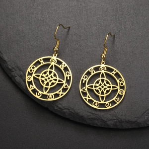 Detailansicht goldener Hexenknoten-Ohrringe mit Mond-Anhänger auf schwarzem Naturstein