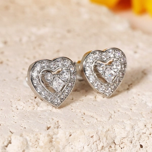 Macro view of heart stud earrings with layered silver metal and pavé zircon stones