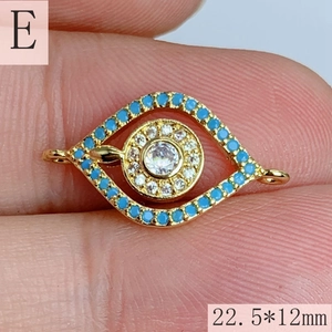 Macro shot of gold Evil Eye charm with blue and white stones, size 22.5x12mm