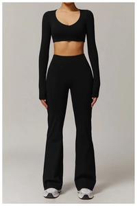 Close-up of black high-waisted flared yoga pants and long sleeve crop top fitness set