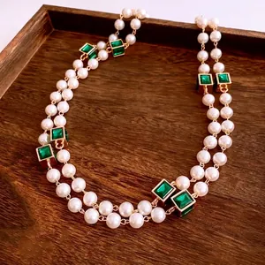 Vintage double layer pearl necklace with emerald square charms on elegant wood tray