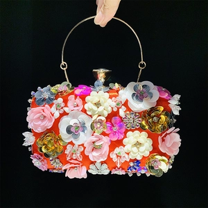Close-up of bright orange evening clutch with colorful 3D floral beads and sequins