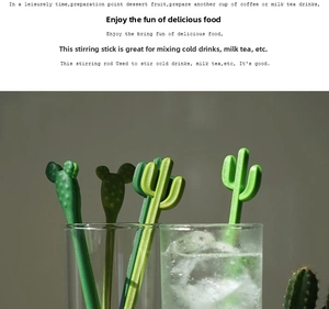 Close-up of four green cactus-shaped drink stirrers in a clear glass for cocktails