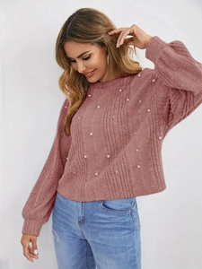 Détails de la texture d'un pull en tricot rose orné de perles élégantes