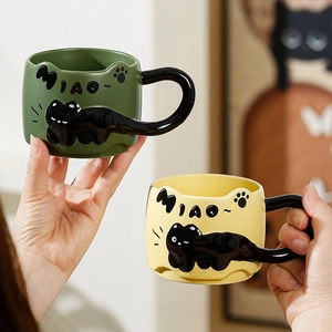 Ceramic black cat mug with 3D tail handle in green and yellow colors for coffee