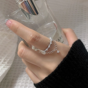 Detail of silver double layer chain ring with star zircon pendants on model finger