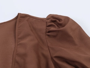 Détail de la robe marron avec manches bouffantes et coutures de précision au col