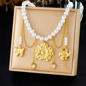 Close-up of gold-plated tassels with floral, butterfly, and heart charms on a pearl necklace