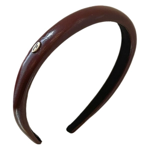 Minimalist deep brown PU leather headband with golden Love engraving on white background