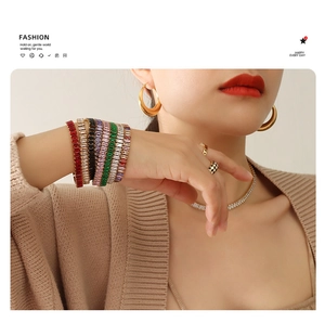 Close-up of multicolored rectangle zircon tennis bracelets stacked on a model's wrist